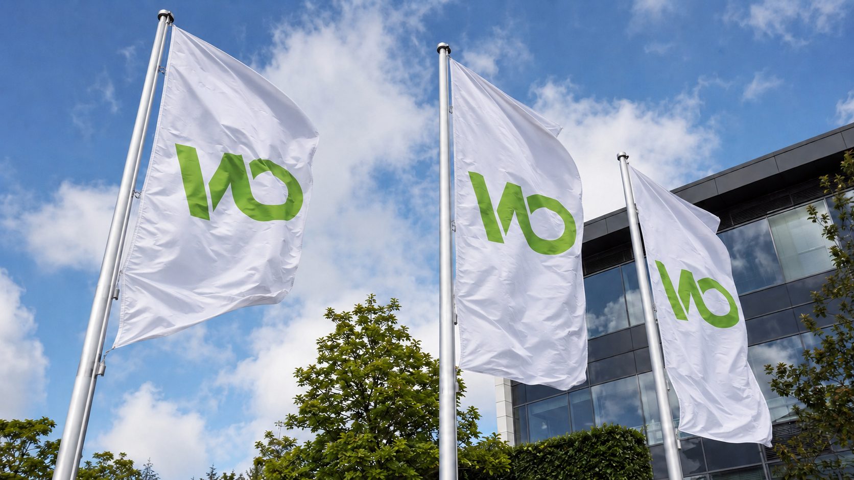 Drei Flaggen mit dem Logo von Wiebe Objektservice vor dem Firmengebäude
