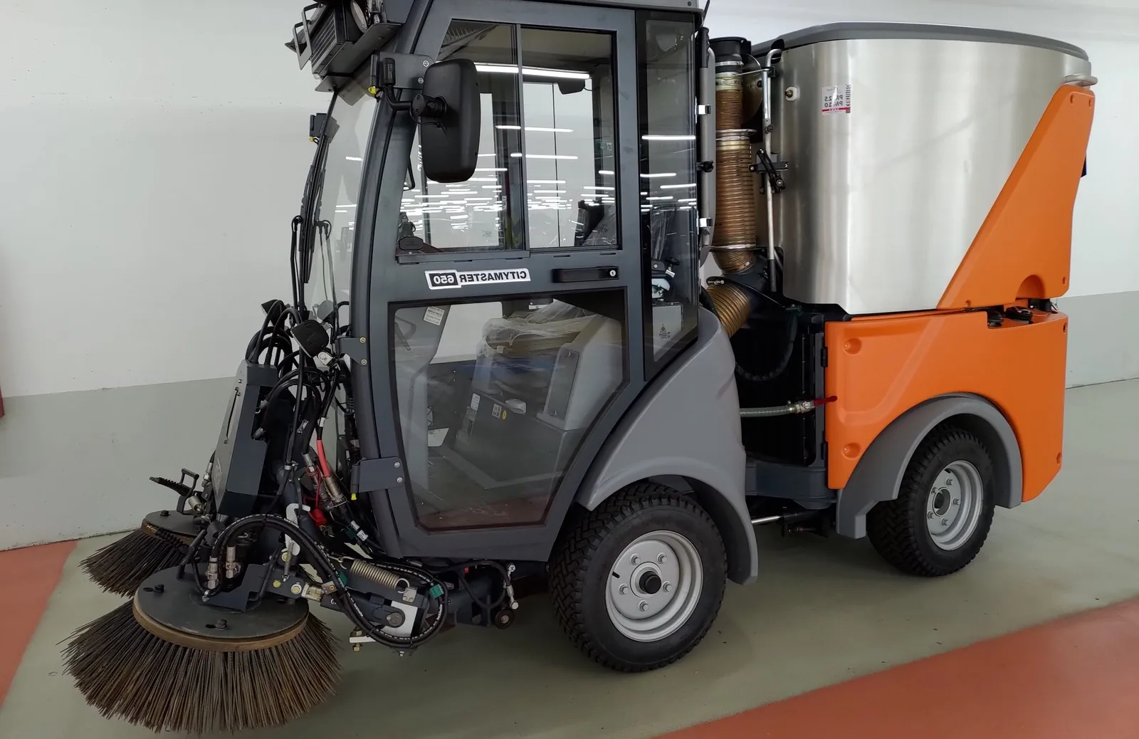 Kehrmaschine entfernt Splitt und Streugut von einer Asphaltfläche